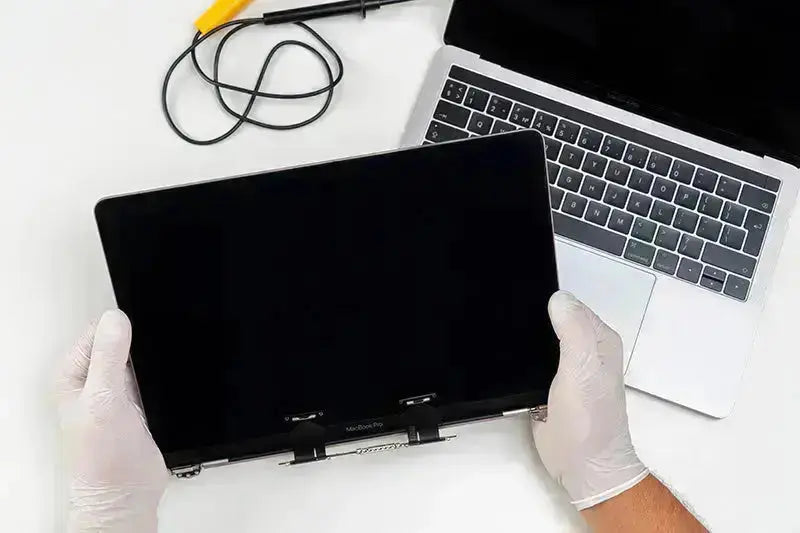 MacBook Pro 14" screen replacement service with technician holding new display panel, Dublin City Centre repairs.